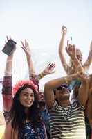 Happy fans with arms raised enjoying at music festival
