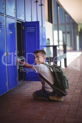 Portrait of boy taking books from locker