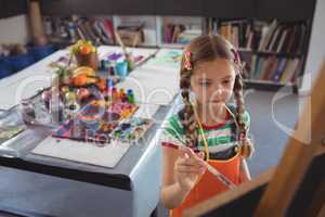 High angle view of girl painting on canvas