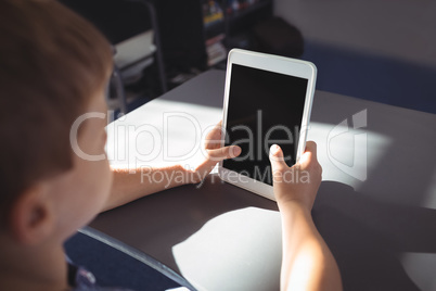 Boy using tablet computer at desk