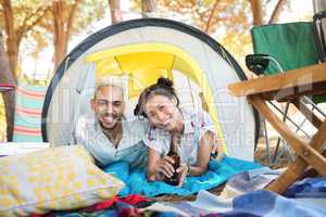 Portrait of smiling couple relaxing in tent