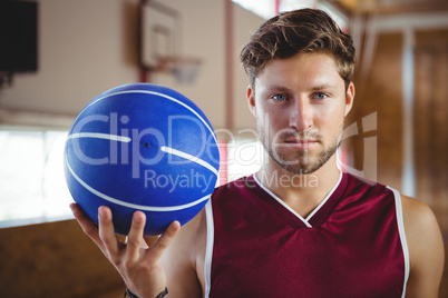 Portrait of confident player holding basketball