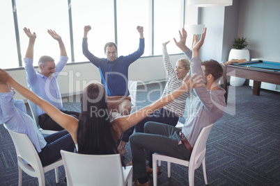 Cheerful business colleagues sitting on chairs at office