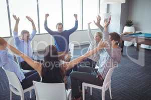 Cheerful business colleagues sitting on chairs at office