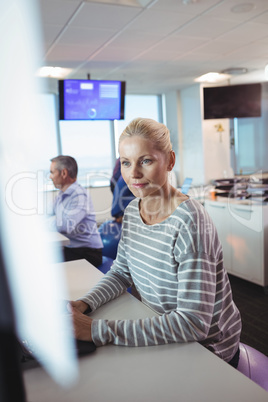 Thoughtful businesswoman sitting on exercise ball at desk