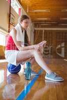 Side view of woman using phone in basketball court