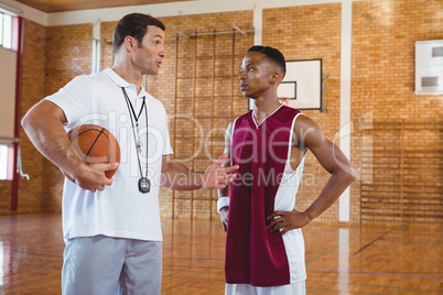 Coach guiding basketball player