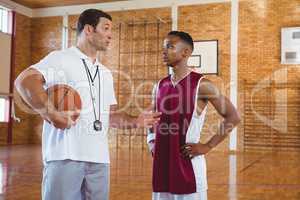 Coach guiding basketball player