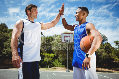 Happy basketball players doing high five