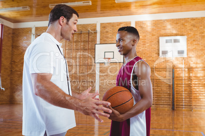 Coach talking with basketball player