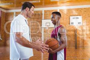 Coach talking with basketball player