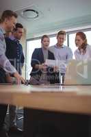 Happy young business colleagues discussing in metting room