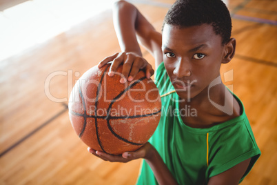 Portrait of male teenager with basketball