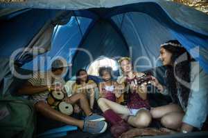 Happy young friends enjoying in tent