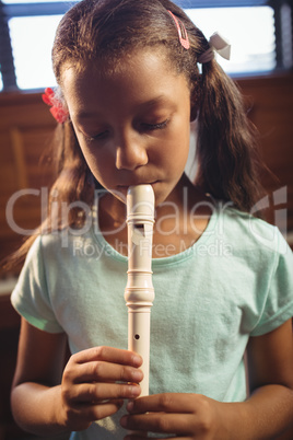Girl playing flute in classroom