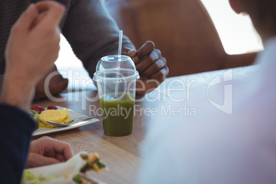 Drink on table by business colleagues at office cafeteria