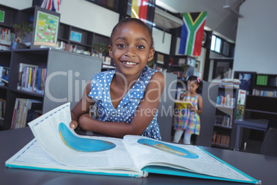 Girl with book at desk in library