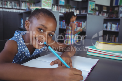 Smiling girl studying in library