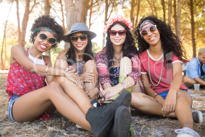 Portrait of happy female friends sitting together at campsite