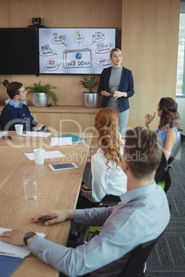 Young businesswoman discussing with colleagues during meeting
