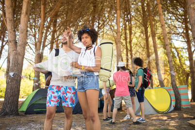 Couple holding map with friends in background