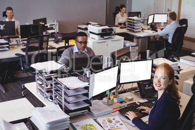 Portrait of businesswoman with colleagues working at office