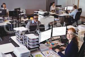 Portrait of businesswoman with colleagues working at office