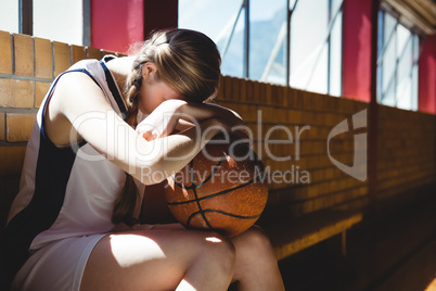 Tired basketball player sitting by window