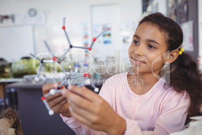 Elementary student examining molecule model