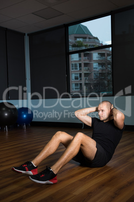 Man exercising on hardwood floor at gym