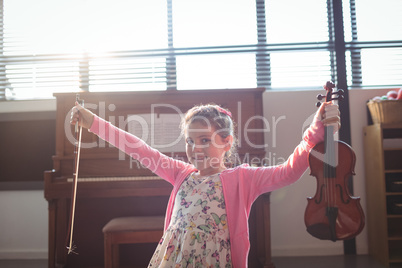 Portrait smiling girl holding violin with arms outstretched