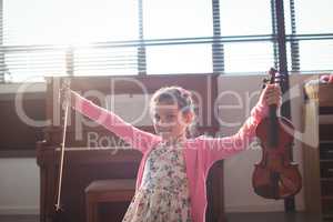 Portrait smiling girl holding violin with arms outstretched