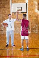 Coach high fiving with basketball player