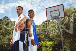 Happy basketball players standing back to back