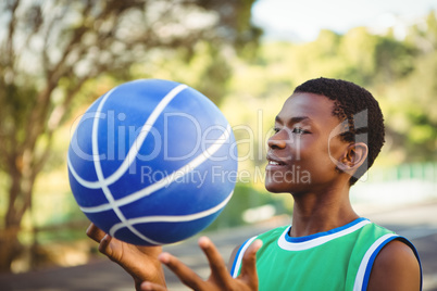 Smiling young man playing with basketball