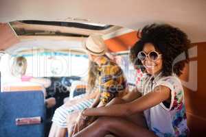 Portrait of smiling woman sitting with friends in camper van