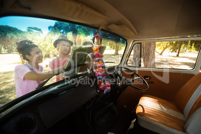 Friends looking at map seen through windshield