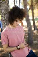 Close up of young man using mobile phone at forest