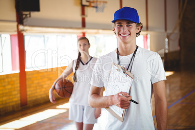 Portrait of male coach with basketball player