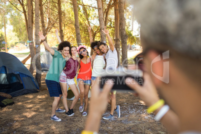 Man photographing friends at campsite