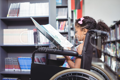 Girl reading book on wheelchair
