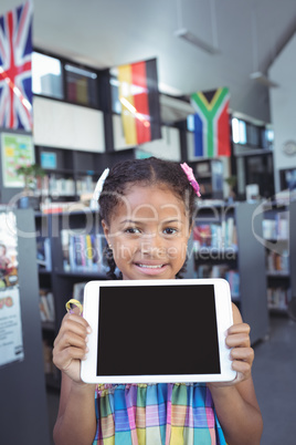 Smiling girl showing tablet computer in library