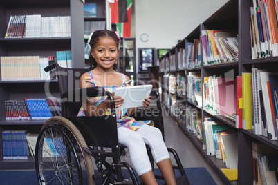 Girl on wheelchair smiling while holding digital tablet