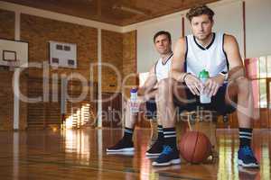 Portrait of confident basketball players sitting on bench