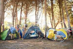 Young friends setting up their tents on field