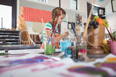 Girl painting in classroom