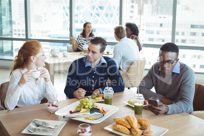 Business entrepreneurs sitting at breakfast table in office