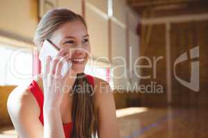 Close up of smiling female basketball player talking on phone