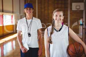 Portrait of smiling basketball player with male coach
