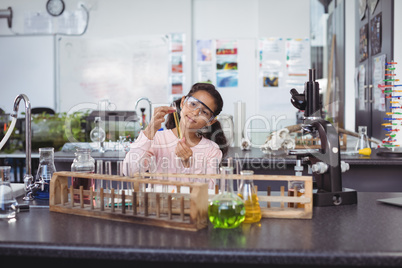 Elementary schoolgirl holding test tube at laboratory